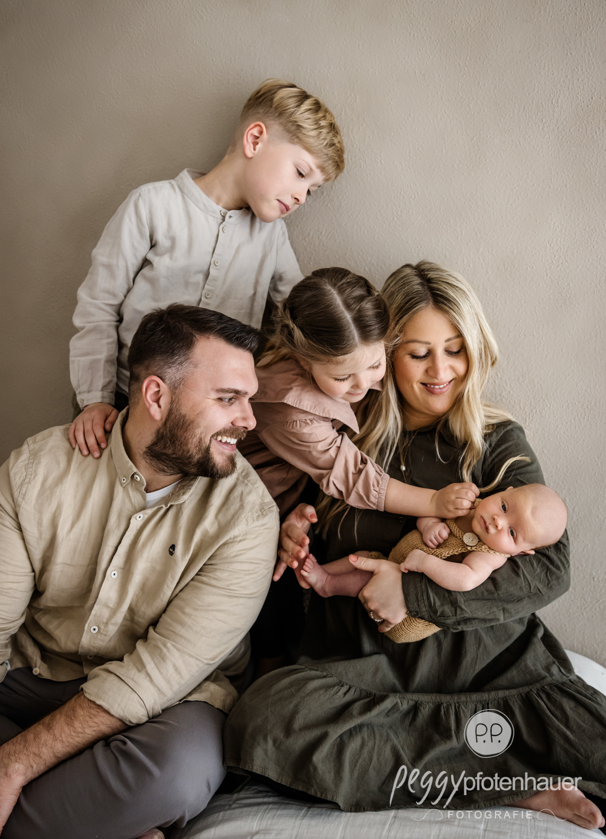 Familie mit Neugeborenem im Fotostudio