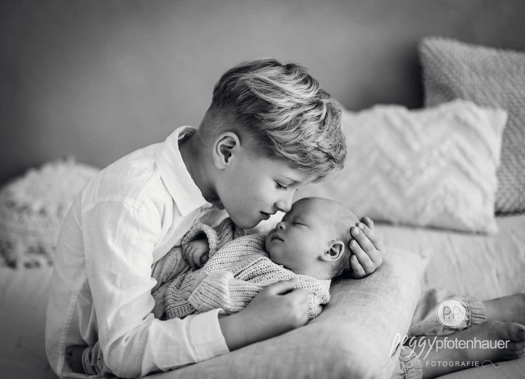 großer Bruder liebevoll mit Baby