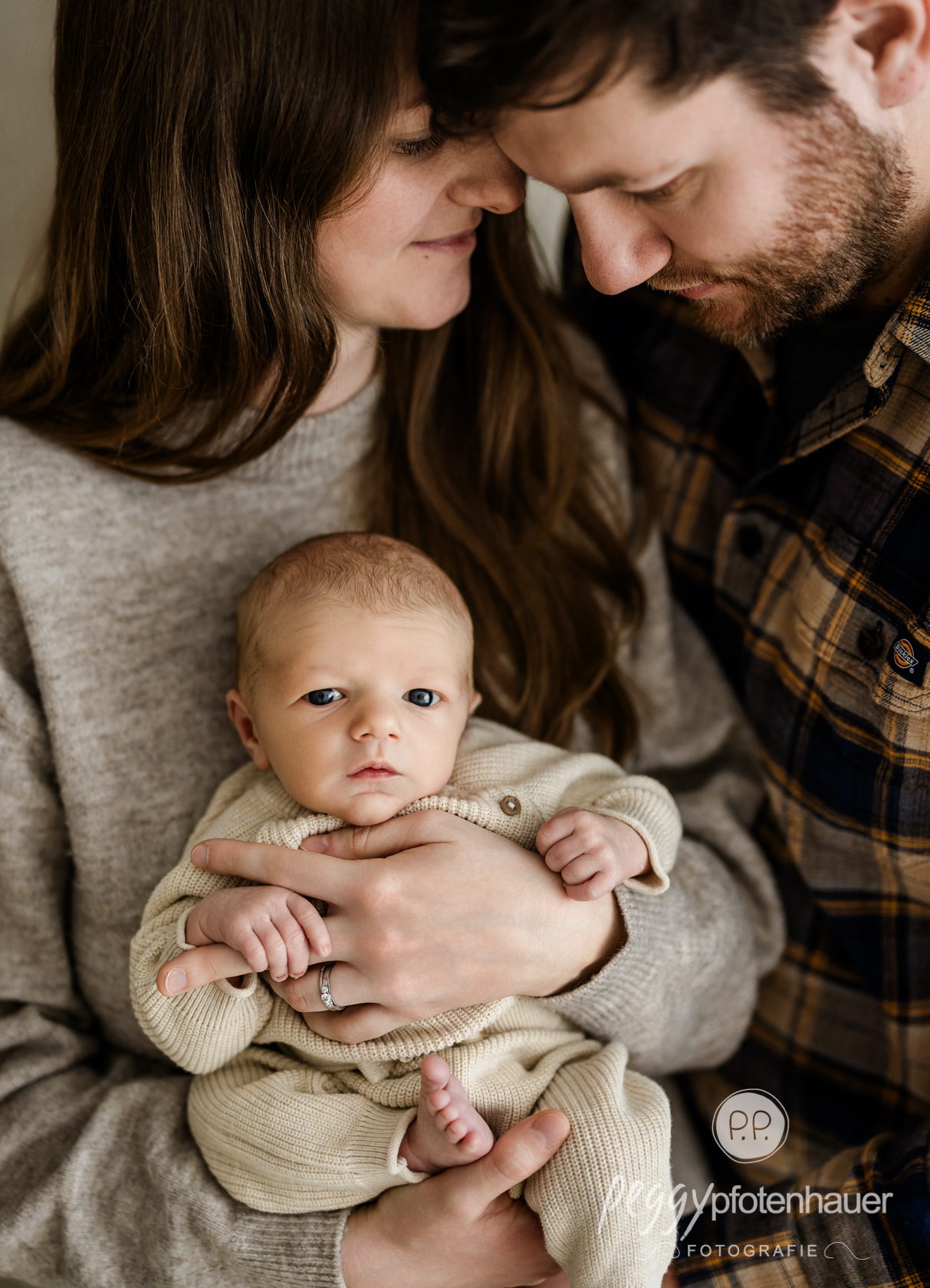 newbornfotograf-bayern Mama und Papa kuscheln innig mit Baby
