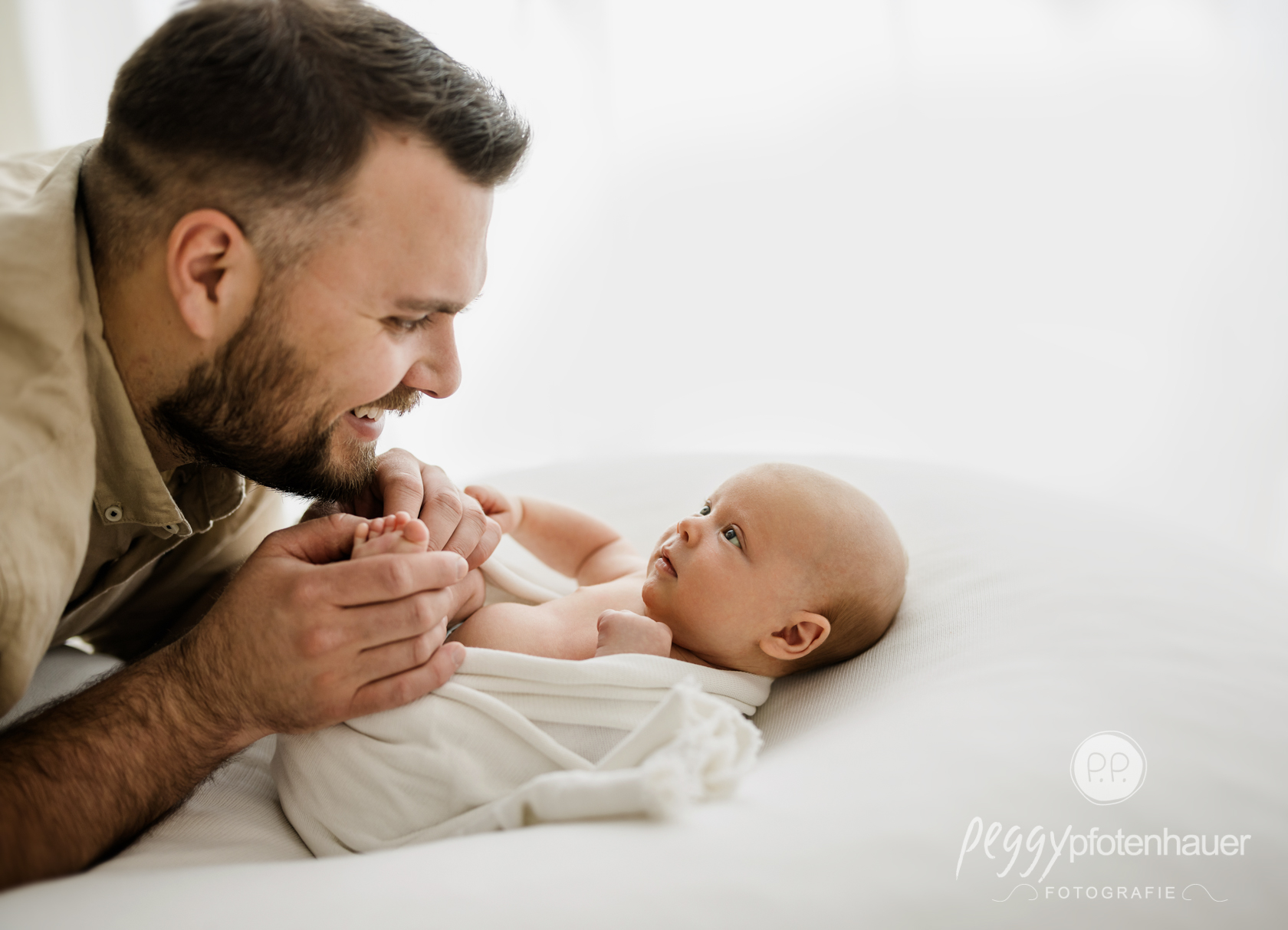Papa schaut liebevoll auf Baby