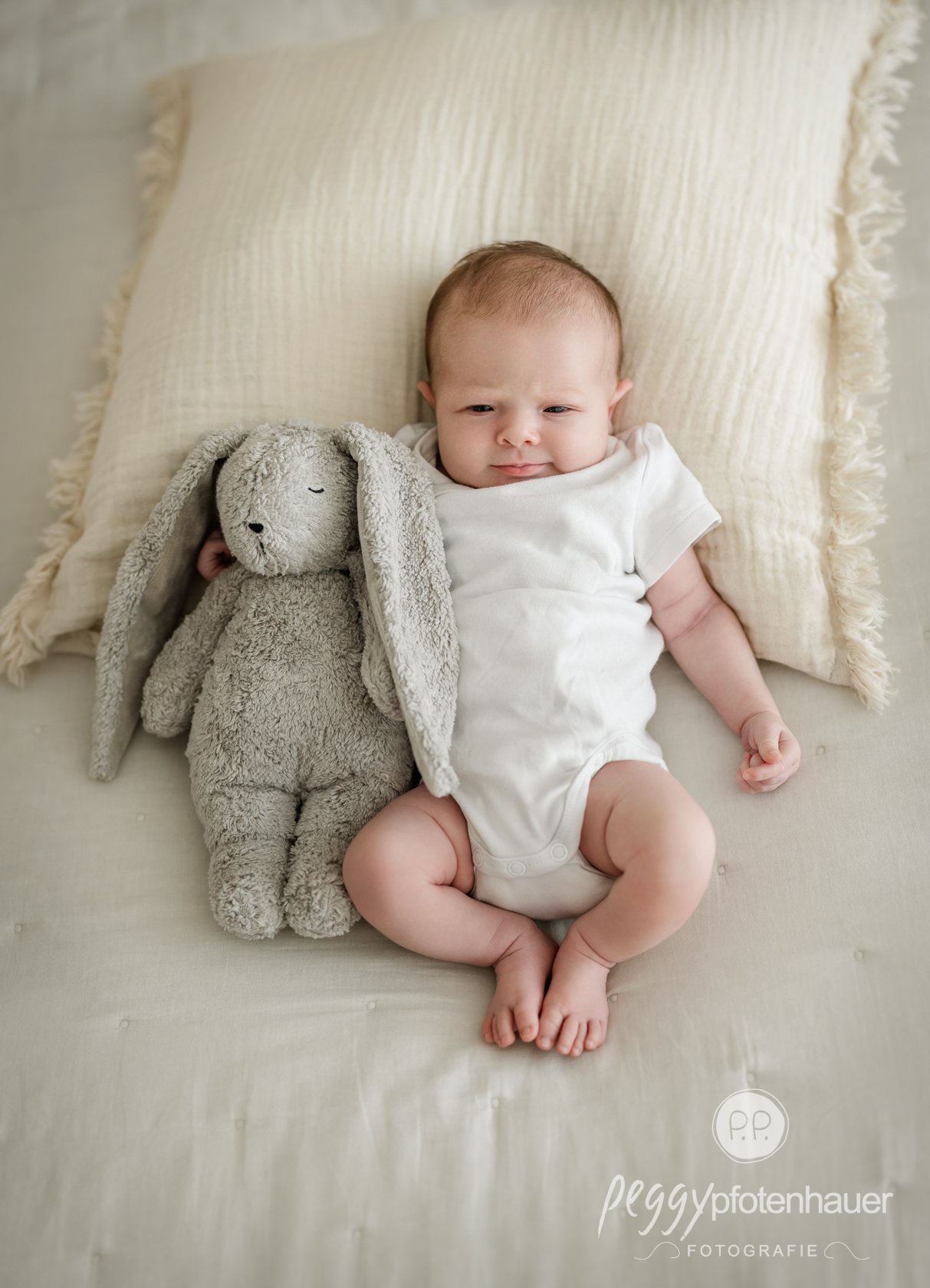 babyfotos-wuerzburg Baby mit Kuscheltier auf Kissen