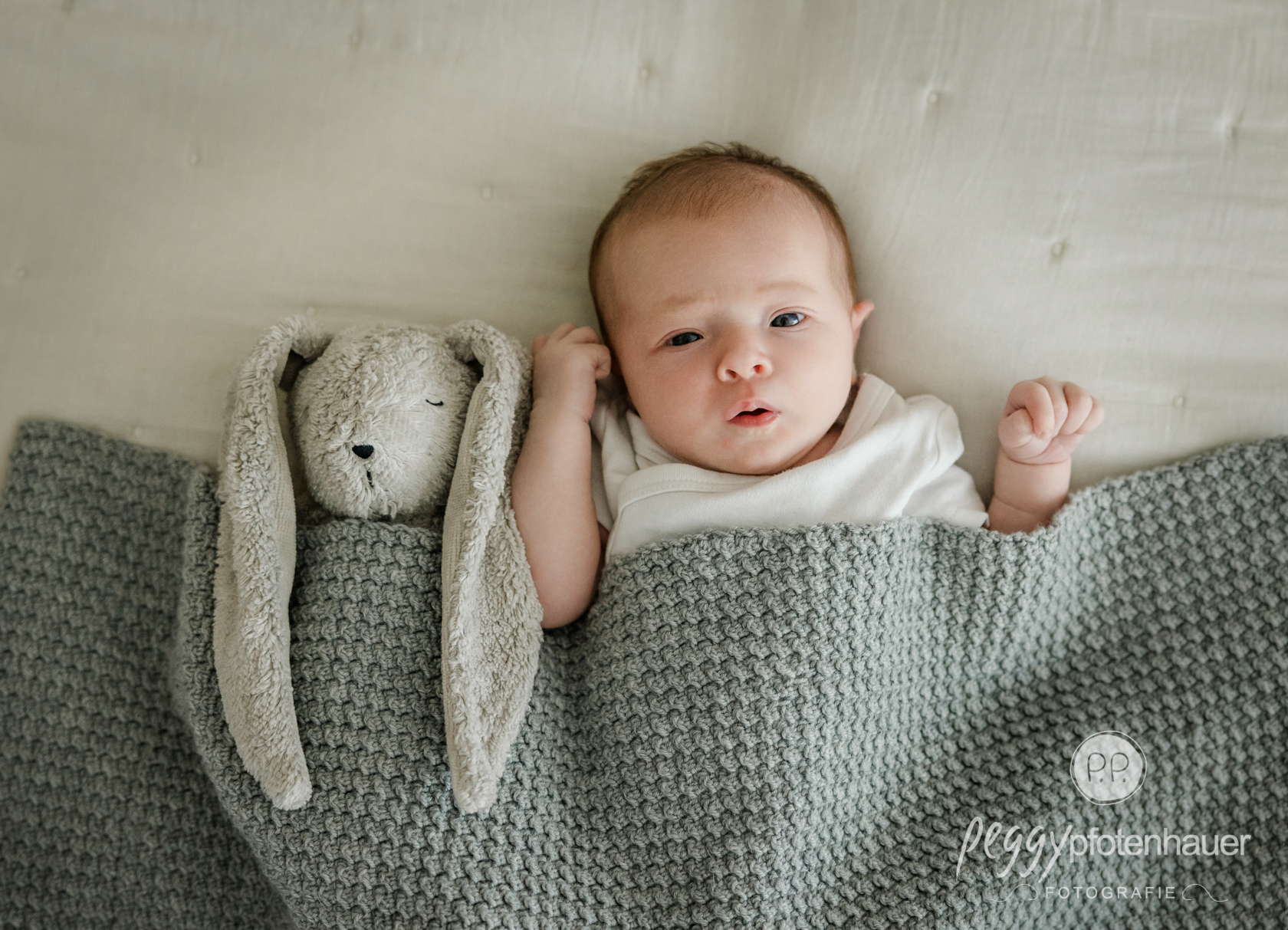 emotionale-babyfotografie Baby auf Decke mit Kuscheltier