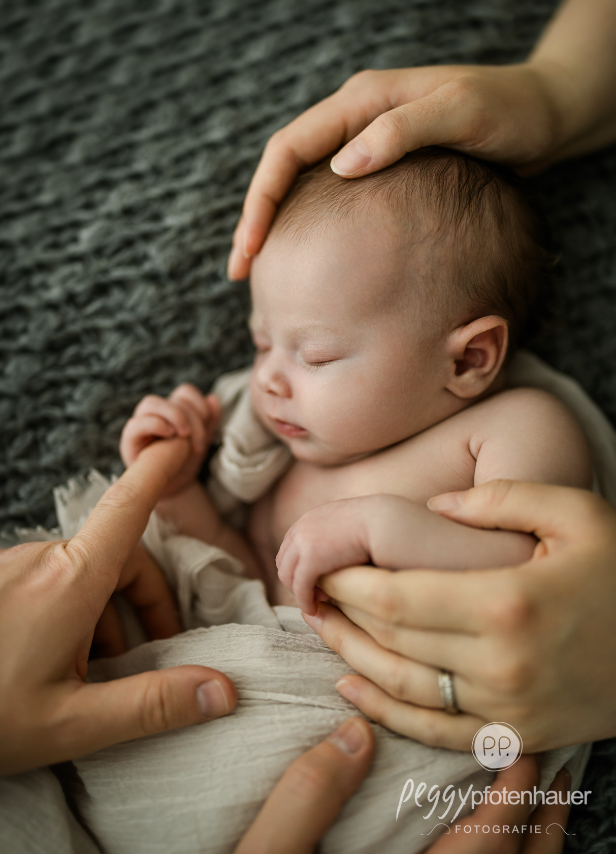 innige-newbornfotos-wuerzburg Baby in Händen von Mama und Papa