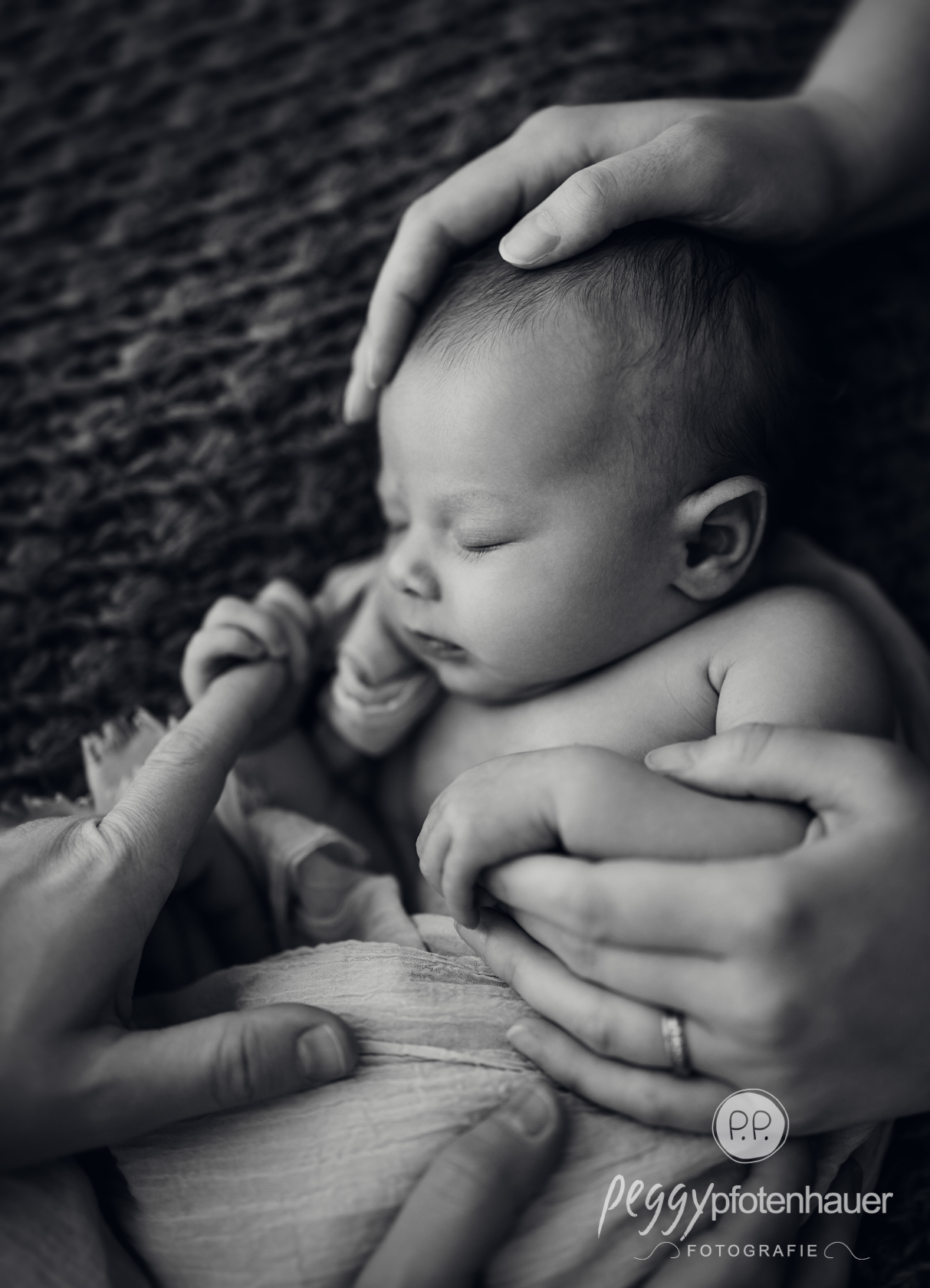 newbornfotograf-wuerzburg Newborn in Händen von Mama und Papa