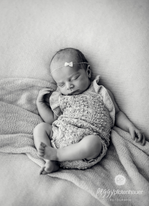 Neugeborenes liegt auf Decke eingekuschelt