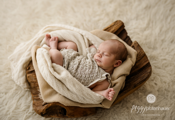Baby liegt in Schale und schläft