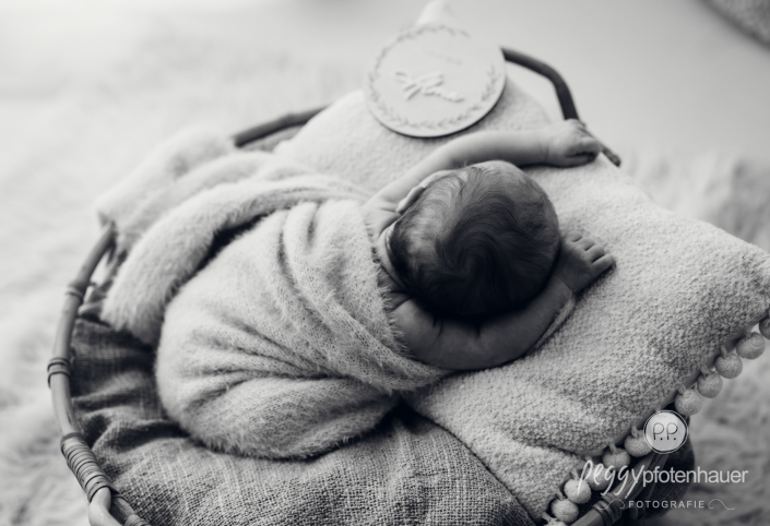 Baby liegt in Körbchen und schläft