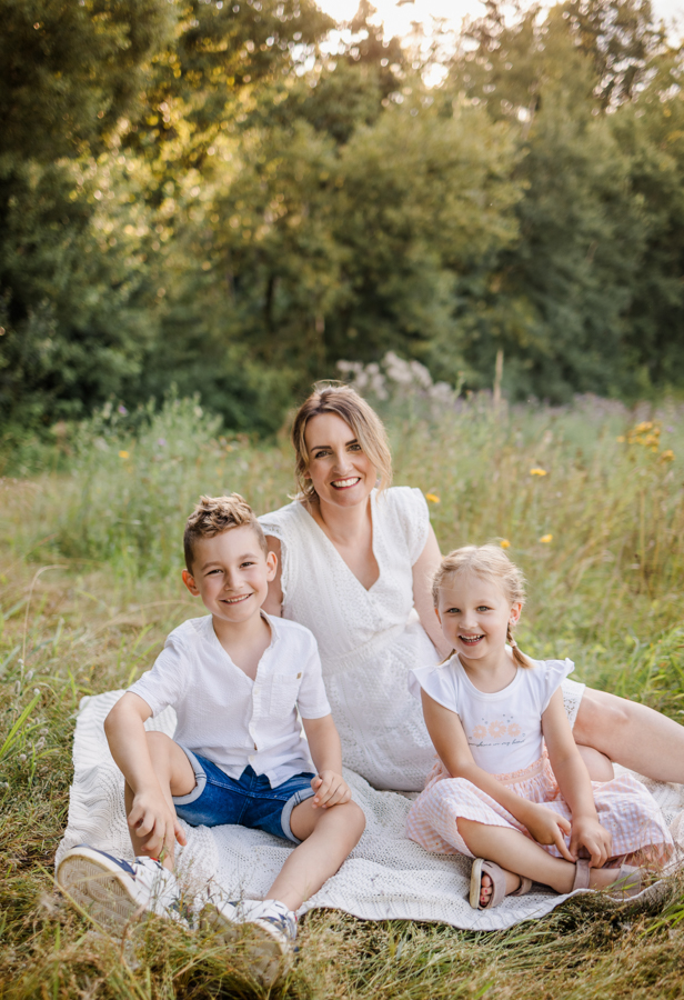 emotionale-familienfotos-bamberg Mama und Kinder sitzen auf Wiese in Bamberg und lachen