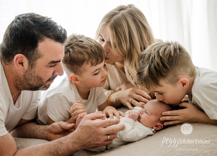 Familie freut sich über Baby und küsst es