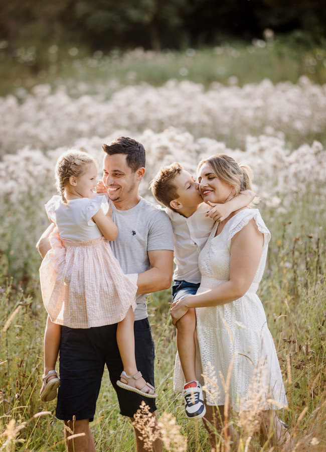 familienfotoshooting-bayreuth Familie steht in Wiese in Bayreuth und kuschelt und hat Spaß