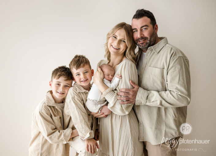 Familie mit drei Kindern lacht glücklich