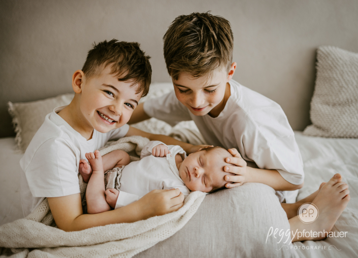 Brüder halten Baby und freuen sich