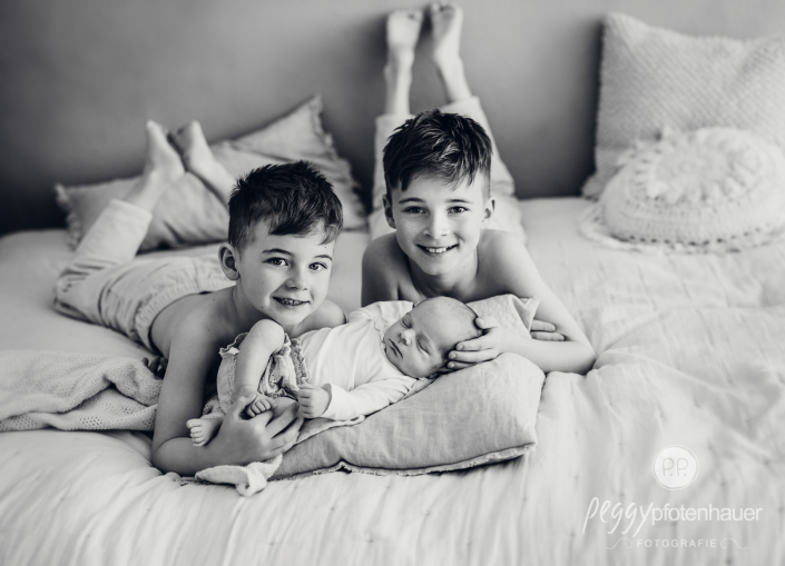 Kinder liegen auf Bett und kuscheln