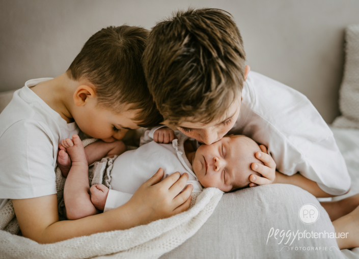 Brüder küssen Baby