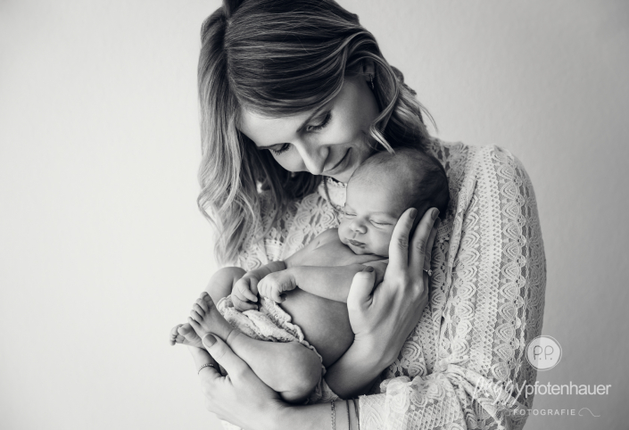 Mama hält Baby ganz innig fest und ist liebevoll