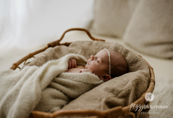 Baby liegt in Körbchen und schläft