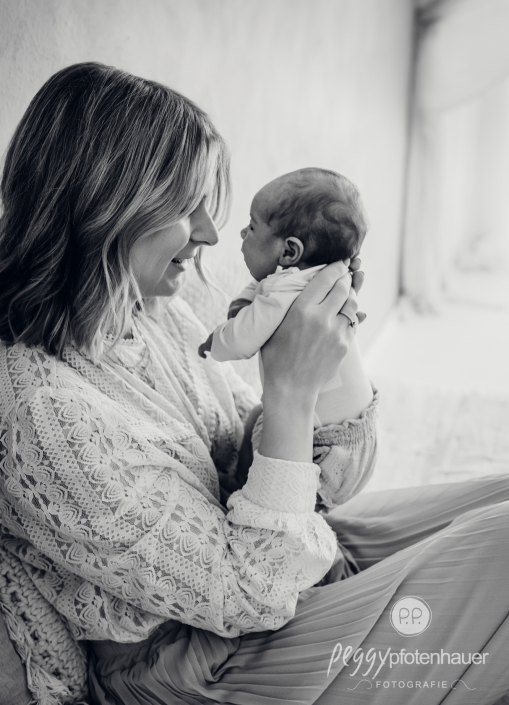 Mama hält Baby ganz innig und ist glücklich