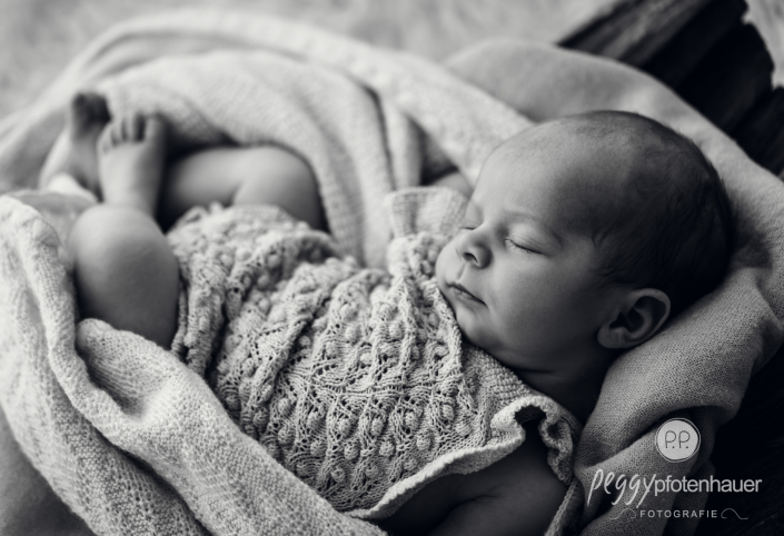 Baby liegt in Schale und schläft