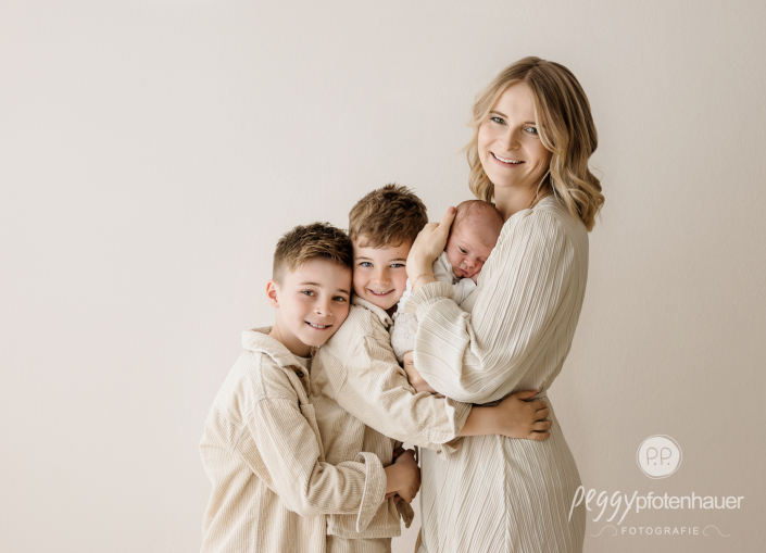 Mama und Kinder stehen eng beisammen und sind glücklich