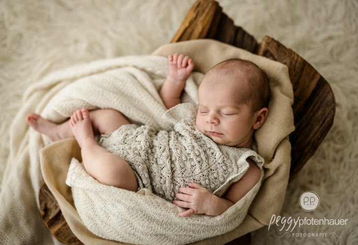 Baby liegt in Schale und schläft