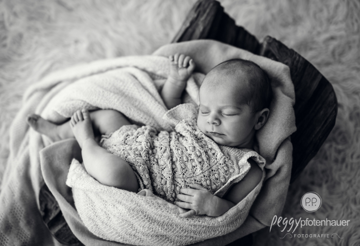 Baby liegt in Schale und schläft