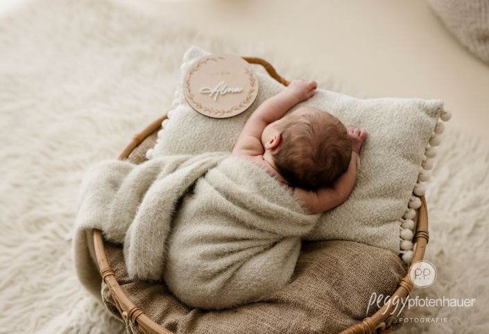 Baby hängt entspannt in Körbchen