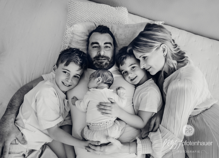 Familie liegt auf Papa und kuschelt