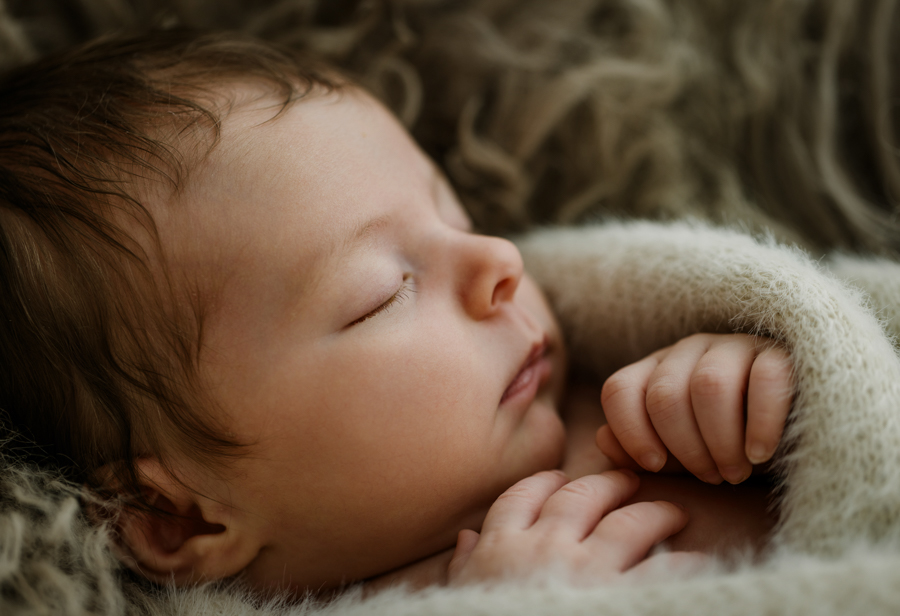Baby liegt in Decke eingekuschelt und schläft