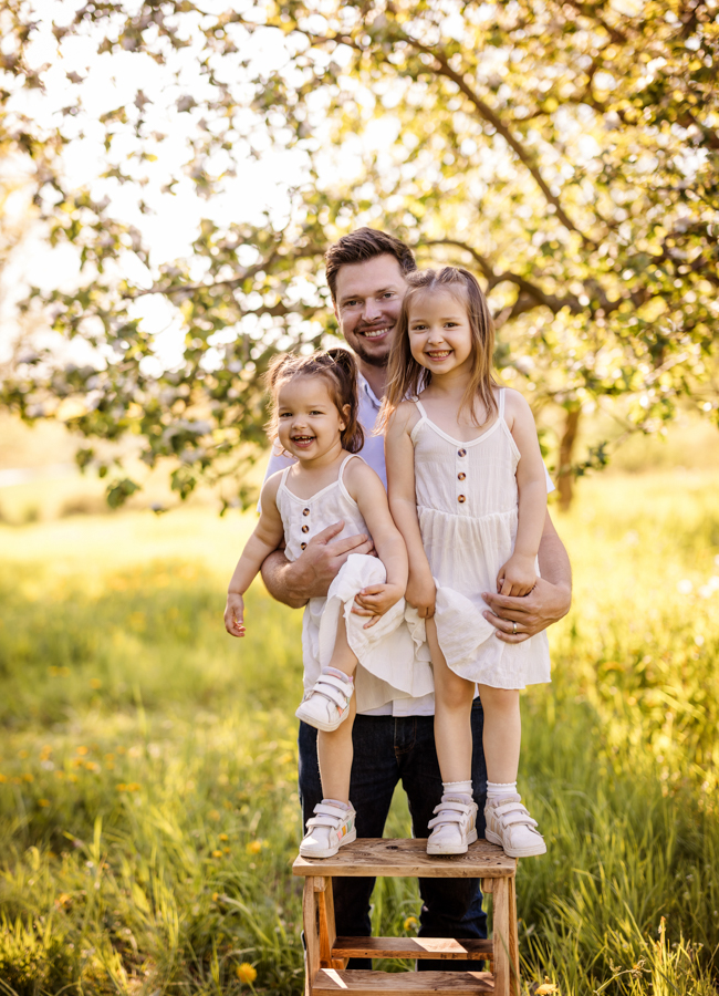 papa-kind-fotos-wuerzburg Papa steht mit Kindern in Frühlingswiese und alle lachen
